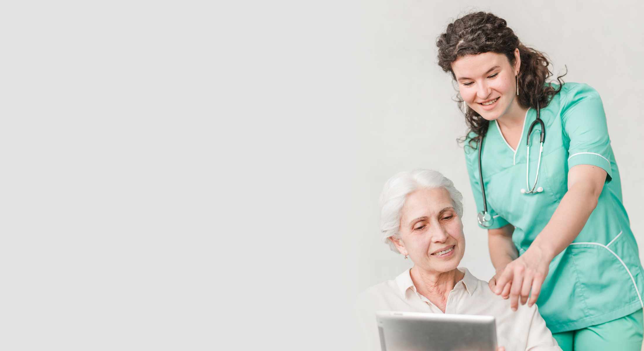 A nurse showing a patient a tablet