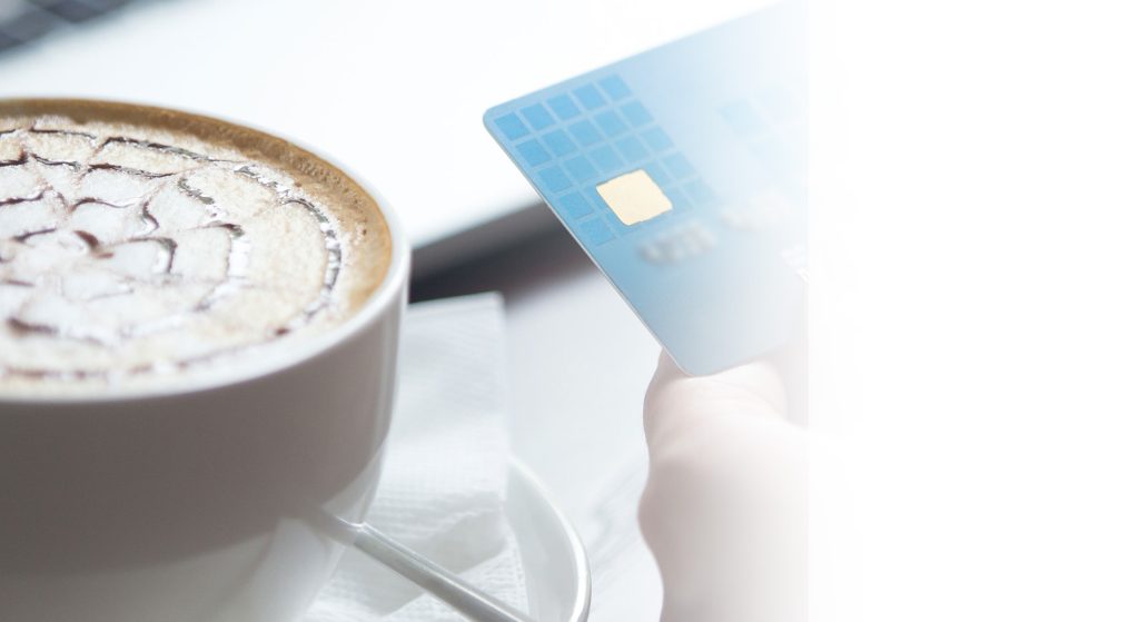 A coffee and a bank card on a café table
